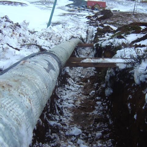 Þarna er skurðurinn orðin snjólaus og því hægt að slaka rörinu ofan í og moka yfir.